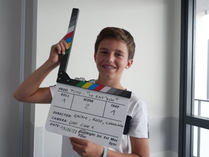 Un enfant avec un clap de cinéma : Tumo propose un atelier Cinema